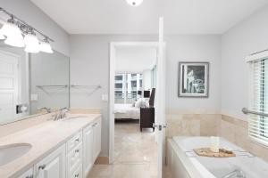 La salle de bains blanche est pourvue d'un lavabo et d'un miroir. dans l'établissement Ritz Carlton Coconut Grove Luxury 2 BR Apt apts, à Miami