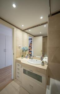 bagno con lavandino e grande specchio di MyHouseSpain - Precioso Ático con gran terraza centro Usera a Madrid