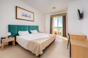um quarto com uma cama grande e vista para o oceano em Hotel Santa Catarina Algarve em Portimão