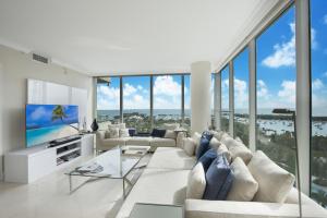 Ritz Carlton Coconut Grove Waterview 2 BR Apt apts في ميامي: غرفة معيشة بأثاث أبيض ونوافذ كبيرة