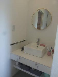 uma casa de banho com um lavatório branco e um espelho. em Casa en Vistalba (Luján de Cuyo)- Mendoza em Vistalba
