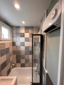 łazienka z wanną i umywalką w obiekcie T2 cosy / quartier calme / magasins d’usine a proximité w mieście Saint-Julien-les-Villas