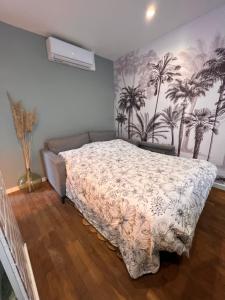 sypialnia z łóżkiem i palmami na ścianie w obiekcie T2 cosy / quartier calme / magasins d’usine a proximité w mieście Saint-Julien-les-Villas