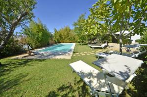 una piscina en un patio con sillas y mesa en Villa Magnolia, en Morciano di Leuca