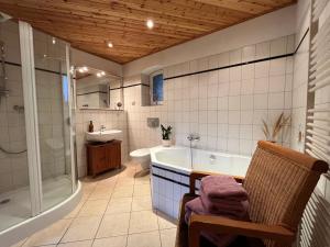 a bathroom with a tub and a shower and a sink at Villa Landidyll mit wunderschönem-seperatem Wellnessbereich in Joachimsthal
