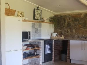 安德伯格The Stone Barn的厨房配有炉灶和石墙