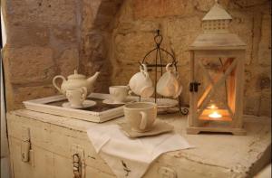 een tafel met theekopjes en een lantaarn erop bij Gildò in Trani