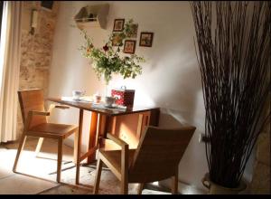uma mesa e cadeiras num quarto com uma planta em Gildò em Trani