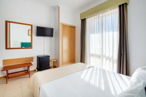 a hotel room with a bed and a window at Hotel Santa Catarina Algarve in Portimão