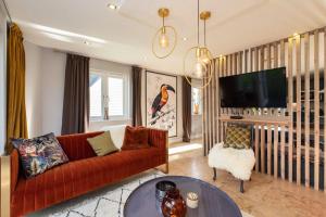 a living room with a red couch and a tv at Luxurious 4 Bedroom New England Style Villa - Trewhiddle V5 in St Austell