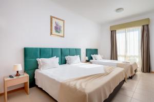 a hotel room with two beds and a window at Hotel Santa Catarina Algarve in Portimão