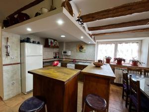 a kitchen with a white refrigerator and a table at Casa Rural Maroto in Campillo