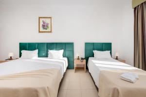 two beds in a room with green walls at Hotel Santa Catarina Algarve in Portimão