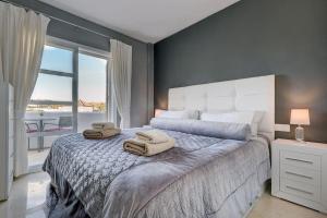 sypialnia z dużym łóżkiem i ręcznikami na nim w obiekcie Stylish Penthouse Duplex at Matchroom Country Club w mieście Santa Fe de los Boliches