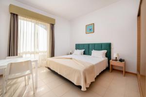 a bedroom with a large bed with a green headboard at Hotel Santa Catarina Algarve in Portimão