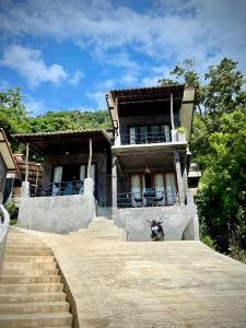 ein Haus mit einem Motorrad, das davor geparkt ist in der Unterkunft Joy Houses in Haad Rin