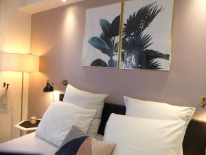 um quarto com 2 camas e almofadas brancas em Studio climatisé Le Marilyn - Dormiratoulouse Blagnac em Blagnac