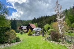 un jardín con una casa en el fondo en Charming cottage KLARA with Sauna, Nature&Privacy near Prague, en Malé Kyšice