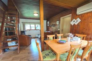 a dining room with a wooden table and chairs at Charming cottage KLARA with Sauna, Nature&Privacy near Prague in Malé Kyšice