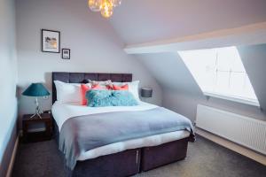 1 dormitorio con 1 cama grande con almohadas azules y rojas en The Fox Inn en Stourbridge