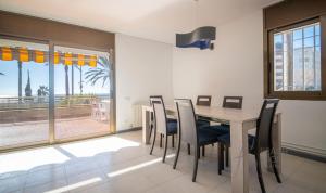 ein Esszimmer mit einem Tisch und Stühlen sowie Meerblick in der Unterkunft R139 Beachfront apartment Guillem in Calafell