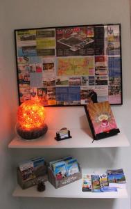 a shelf with a bulletin board and a lamp and books at Kerstins Bed and Breakfast in Egmond aan Zee