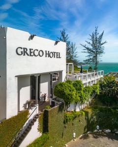 ein weißes Gebäude mit einem Schild, das greco Hotel liest in der Unterkunft Greco Hotel in Búzios
