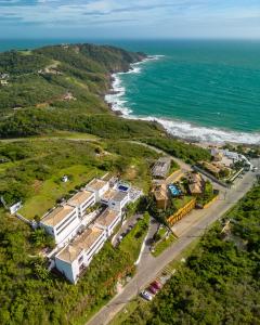 uma vista aérea de uma casa ao lado do oceano em Greco Hotel em Búzios