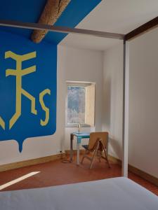 een slaapkamer met een tafel en een blauwe muur bij Domaine La Ferme HI bride in Villelaure