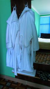 un estante de ropa blanca colgando de una pared en Poti Hotel, en Poti