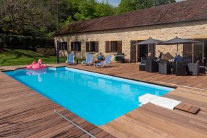 a swimming pool in front of a house at Maison de vacances avec piscine in Montignac