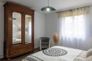sypialnia z komodą, łóżkiem i lustrem w obiekcie Maison de vacances avec piscine w mieście Montignac +20 zdjęć