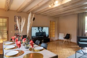 a living room with a table and a tv at Maison de vacances avec piscine in Montignac