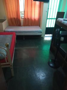 um quarto com uma cama, uma secretária e uma janela em Hostel Colonial hospedagem domiciliar no Rio de Janeiro