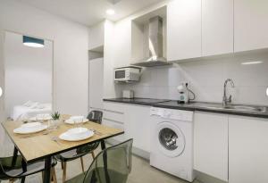 a kitchen with a table and a washing machine at Fantastic apartment in the heart of Alicante in Alicante
