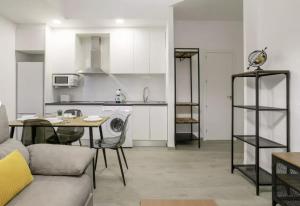 a living room with a couch and a table and a kitchen at Fantastic apartment in the heart of Alicante in Alicante