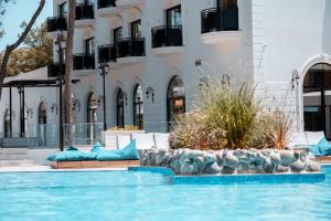 a swimming pool in front of a building at Diamma Resort Conference & Spa in Durrës