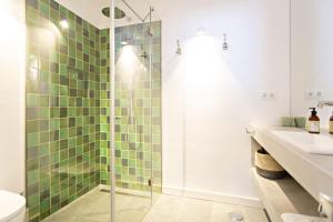 a bathroom with a shower with green tiles at Casa da Tavira in Tavira