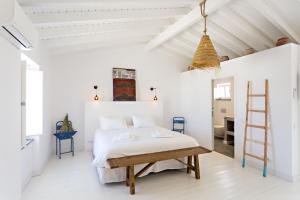 a white bedroom with a bed and a ladder at Casa da Tavira in Tavira