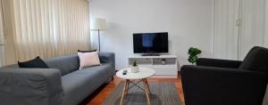 a living room with a couch and a tv at Nice room close to Melb Airport in Melbourne