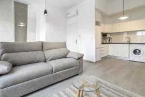uma sala de estar com um sofá e uma cozinha em Very nice and modern flat, in Alicante Center em Alicante