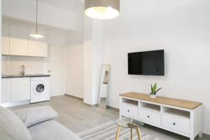 ein Wohnzimmer mit einem Sofa und einem Fernseher an der Wand in der Unterkunft Very nice and modern flat, in Alicante Center in Alicante