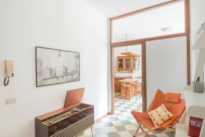 ein Wohnzimmer mit einem Klavier und einem Stuhl in der Unterkunft Interno66 in Brescia