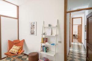 a hallway with a chair and book shelves at Interno66 in Brescia