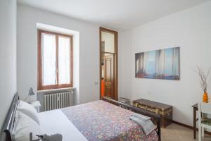 Schlafzimmer mit einem Bett, einem Tisch und einem Fenster in der Unterkunft Interno66 in Brescia