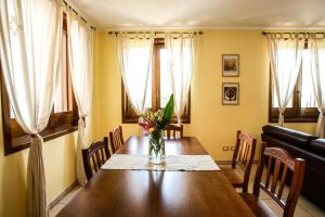 una mesa de comedor con un jarrón de flores. en Ellea Resort en San Michele Salentino