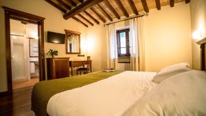 a bedroom with a large white bed in a room at Relais La Corte di Bettona in Bettona