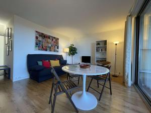 salon ze stołem i niebieską kanapą w obiekcie Appartement rénové avec clim, parking et terrasse à 500m du port - FR-1-225C-113 w mieście Banyuls-sur-Mer