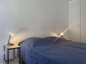 sypialnia z niebieskim łóżkiem i lampką na stole w obiekcie Appartement rénové avec clim, parking et terrasse à 500m du port - FR-1-225C-113 w mieście Banyuls-sur-Mer