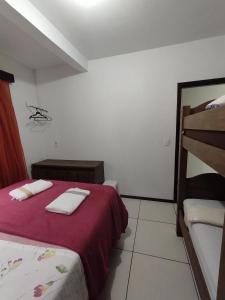 a bedroom with two beds and a bunk bed at Apartamento de hospedagem-calendula in Joinville